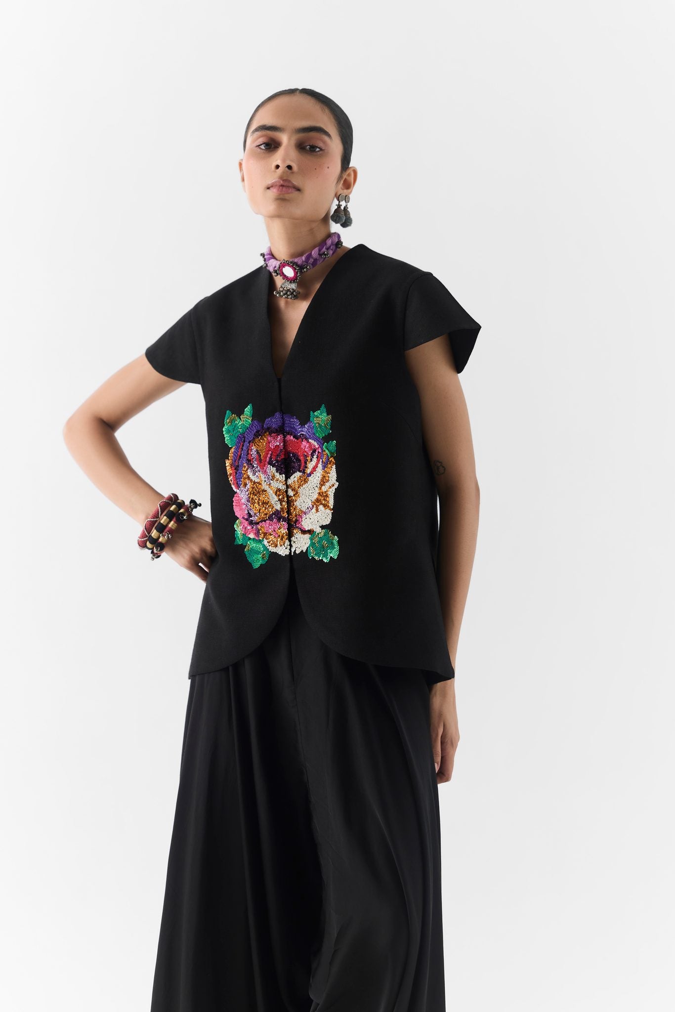 Side view showing draped dhoti pants and fitted vest of the Black Garden Rose set